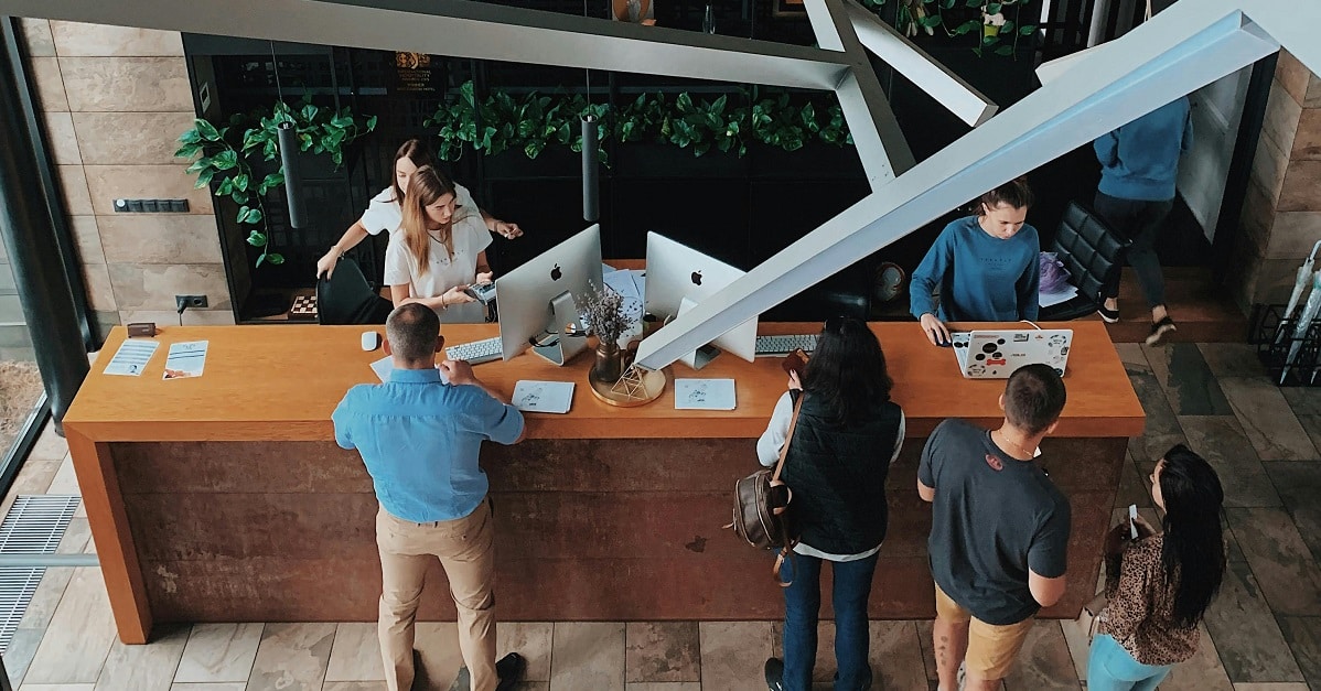 Guests having their IDs checked while checking into a hotel